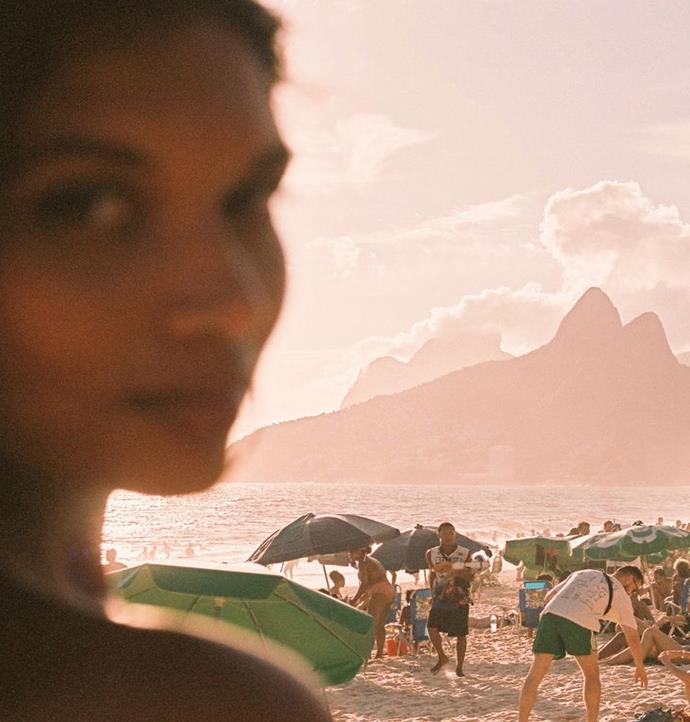 A beach portrait in warm evening light, with Rio’s coastline behind.